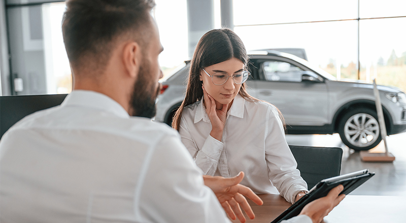 Personas conversando en un concesionario automovilístico